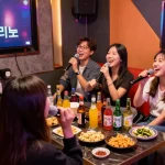 Guests enjoying the unique 인천쓰리노 experience in a lively karaoke room with drinks and laughter.