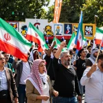 Massive Munich rally focused on Iran with diverse crowd holding banners and chanting for freedom.